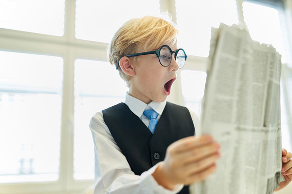 male student reading newspaper