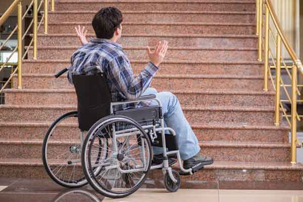 Picture of boy in wheelchair at the bottom of steps